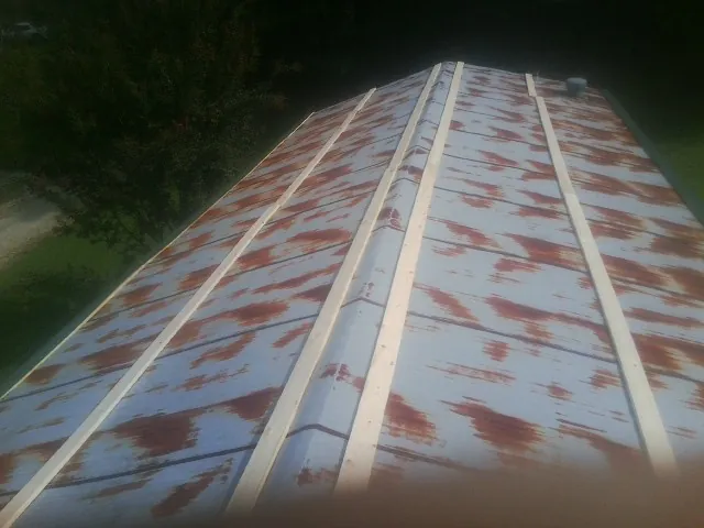 Rusted metal roof panels with new wood purlins before replacement — Storm Damage Roof Repair in Farmington by Roofing Brothers